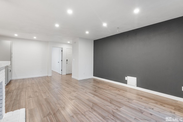 unfurnished living room featuring light wood-type flooring and a fireplace