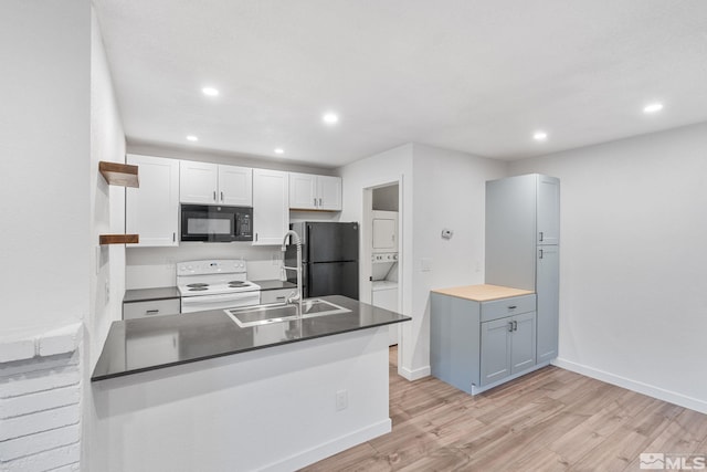 kitchen with light hardwood / wood-style flooring, white cabinetry, black appliances, and kitchen peninsula