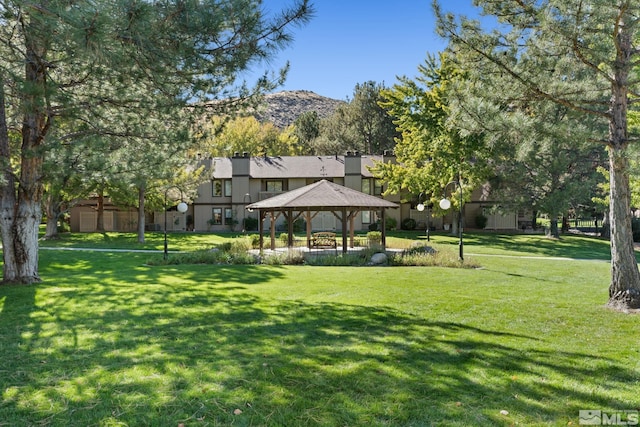 view of community with a gazebo, a mountain view, and a lawn