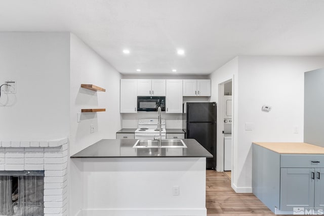 kitchen featuring kitchen peninsula, white cabinetry, black appliances, light hardwood / wood-style floors, and sink