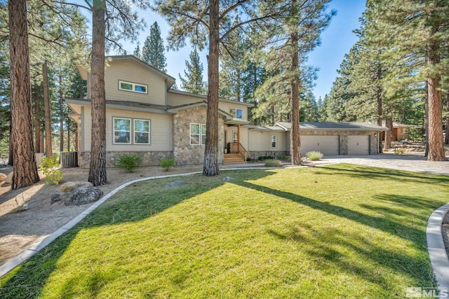 view of front facade featuring cooling unit, a garage, and a front lawn