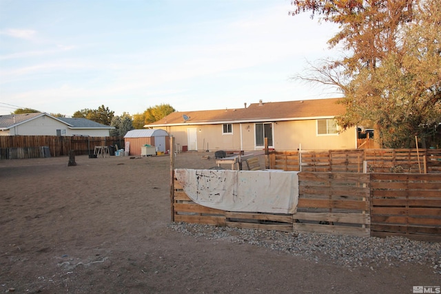 rear view of property with a storage unit