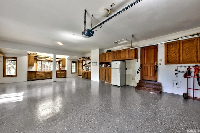 garage with white fridge and a garage door opener