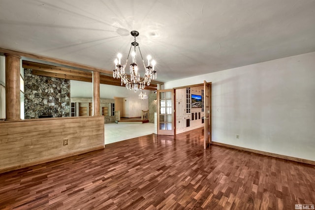 unfurnished dining area featuring hardwood / wood-style flooring, a notable chandelier, and a fireplace