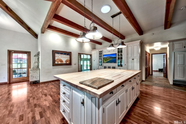 kitchen with white cabinetry, hanging light fixtures, a kitchen island, and wooden counters