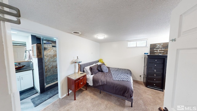 bedroom with a textured ceiling and light colored carpet