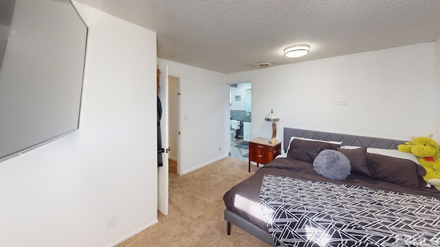 bedroom with light carpet and a textured ceiling