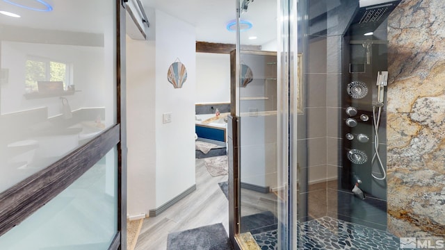 bathroom with hardwood / wood-style flooring and an enclosed shower