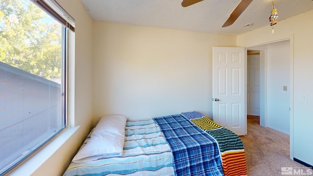 bedroom featuring a textured ceiling, carpet flooring, and ceiling fan