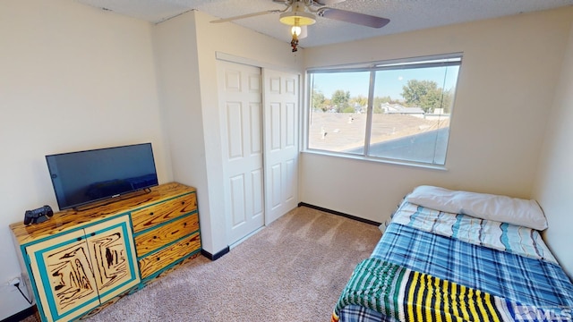 carpeted bedroom with a textured ceiling, a closet, and ceiling fan