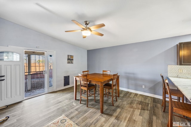 dining area with ceiling fan, wood-type flooring, and vaulted ceiling