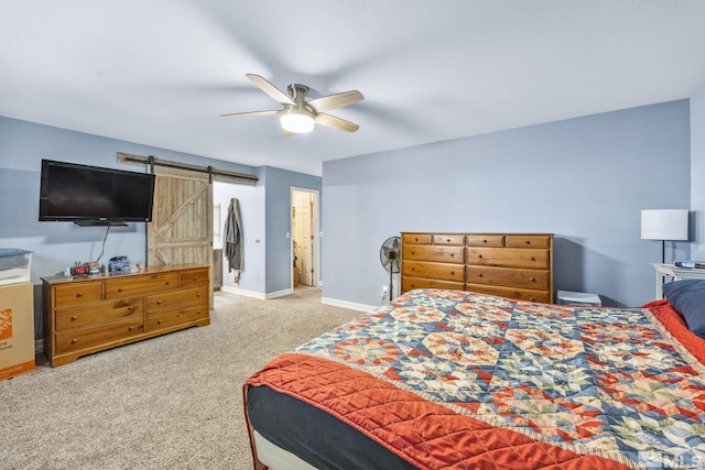 carpeted bedroom featuring a barn door and ceiling fan