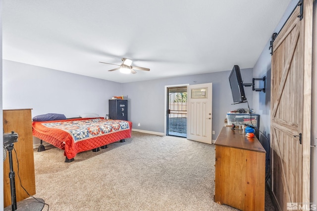 carpeted bedroom with a barn door, ceiling fan, and access to exterior