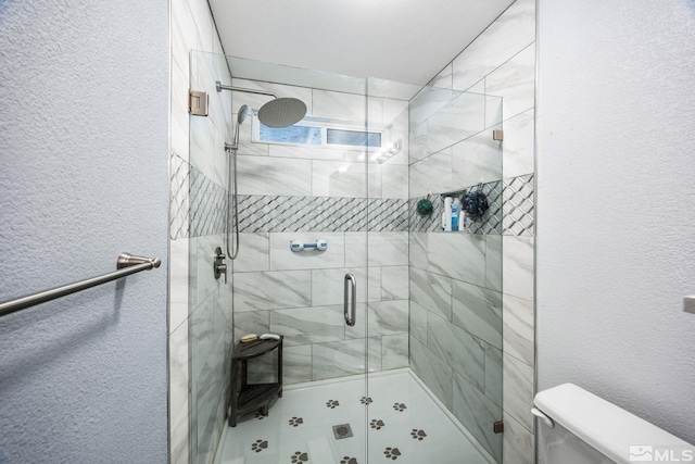 bathroom featuring toilet and a shower with door