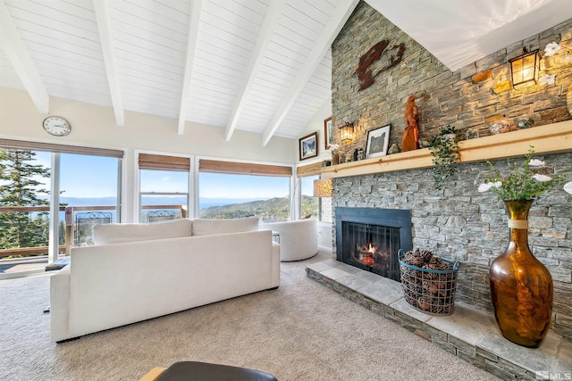 carpeted living room with a mountain view, beam ceiling, high vaulted ceiling, and a fireplace