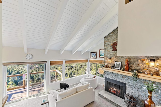 living room with high vaulted ceiling, a stone fireplace, carpet flooring, and beam ceiling