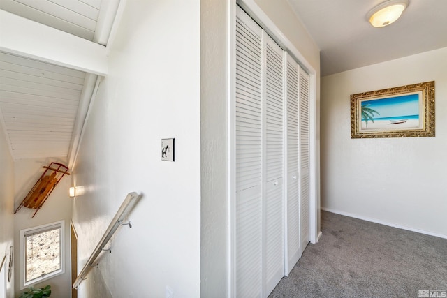 corridor featuring carpet and vaulted ceiling with beams