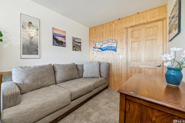 carpeted living room with wood walls