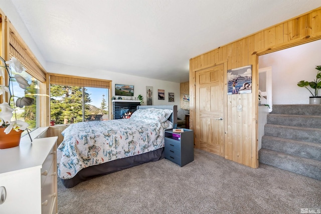 bedroom featuring carpet floors and wood walls