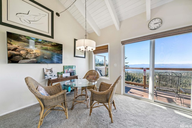 carpeted dining space featuring a mountain view, vaulted ceiling with beams, an inviting chandelier, and wooden ceiling