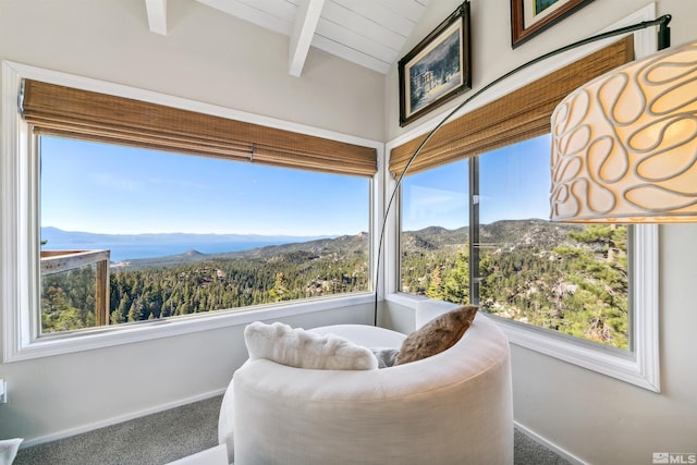 sunroom featuring a mountain view, lofted ceiling with beams, and plenty of natural light