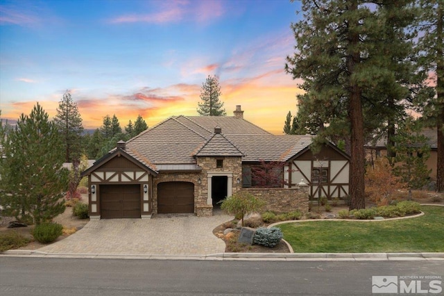 view of front of house featuring a garage and a lawn