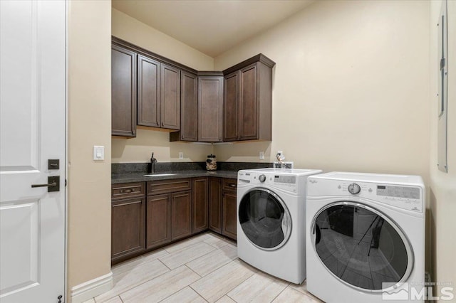 washroom featuring cabinets, washer and dryer, and sink