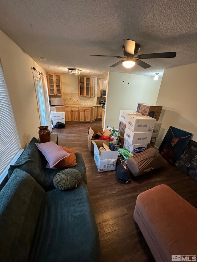 living room with dark hardwood / wood-style floors, a textured ceiling, and ceiling fan