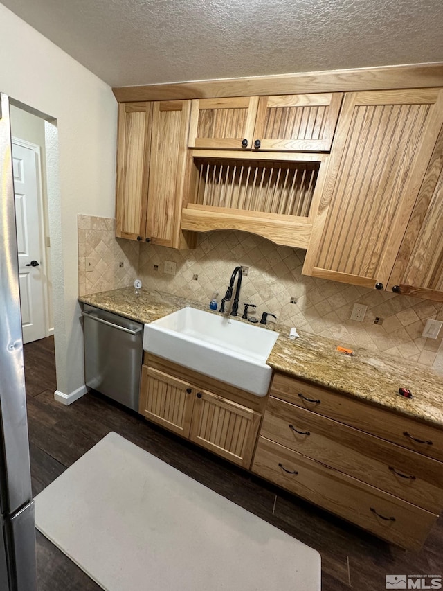 kitchen with light brown cabinets, decorative backsplash, stainless steel dishwasher, dark hardwood / wood-style floors, and sink