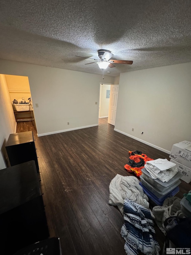 unfurnished living room with a textured ceiling, dark hardwood / wood-style floors, and ceiling fan