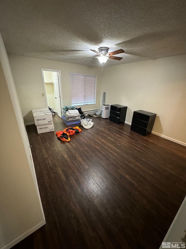 misc room with ceiling fan, a textured ceiling, and dark hardwood / wood-style floors