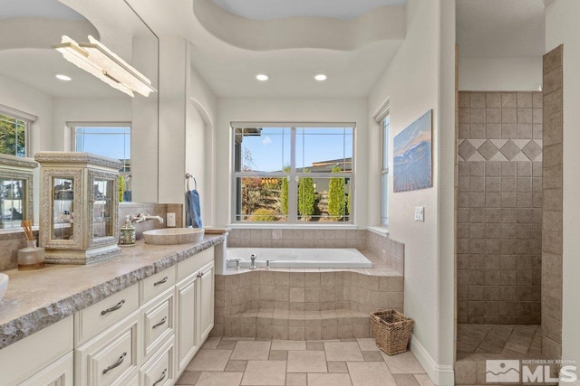 bathroom with vanity and shower with separate bathtub