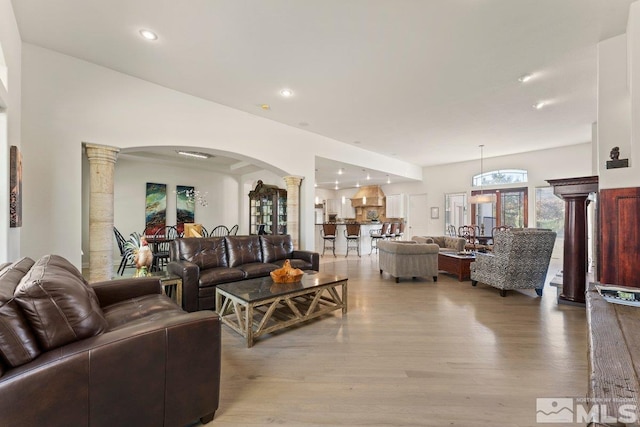 living room featuring light hardwood / wood-style flooring and ornate columns