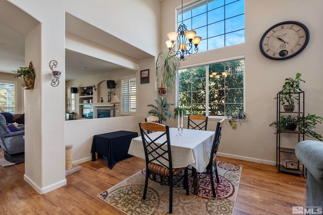 dining space with light hardwood / wood-style flooring and a notable chandelier