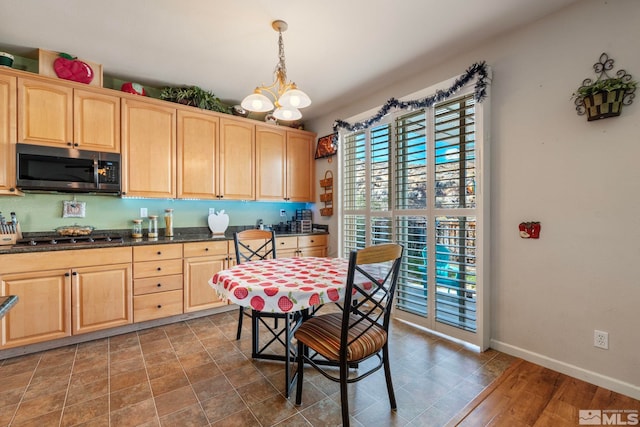 kitchen with pendant lighting, light brown cabinets, and stainless steel appliances