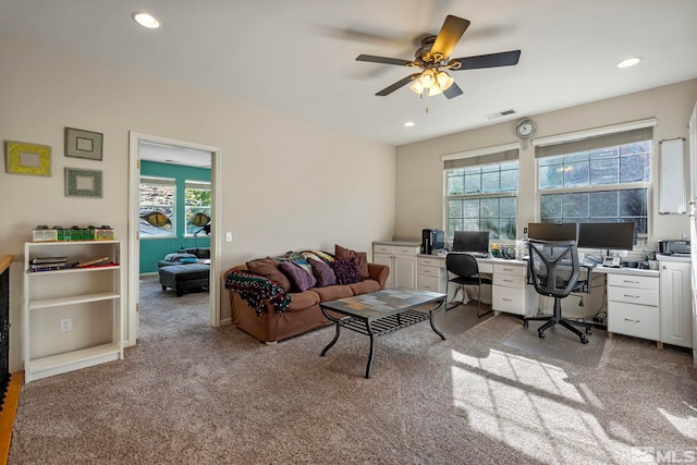 carpeted office space featuring ceiling fan