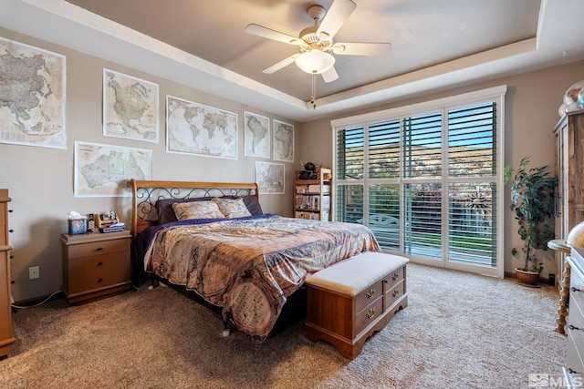 carpeted bedroom featuring a raised ceiling, access to outside, and ceiling fan