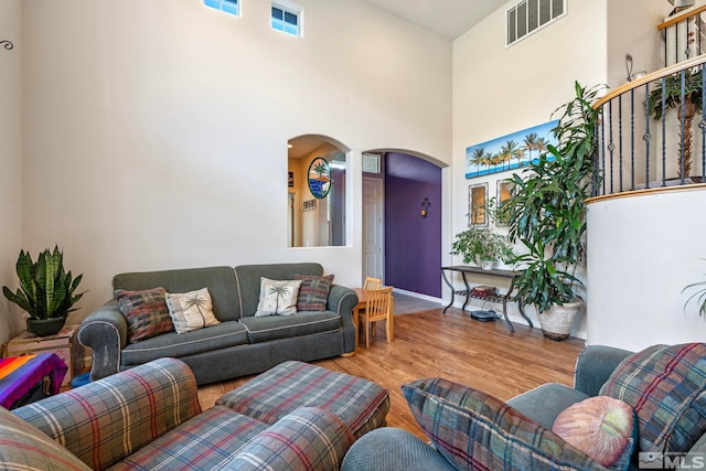 living room featuring a high ceiling and light hardwood / wood-style flooring