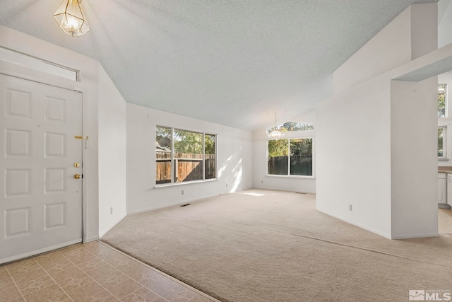 interior space featuring an inviting chandelier, lofted ceiling, and a textured ceiling