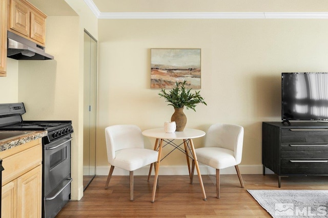 kitchen featuring light brown cabinetry, ornamental molding, gas stove, and hardwood / wood-style flooring