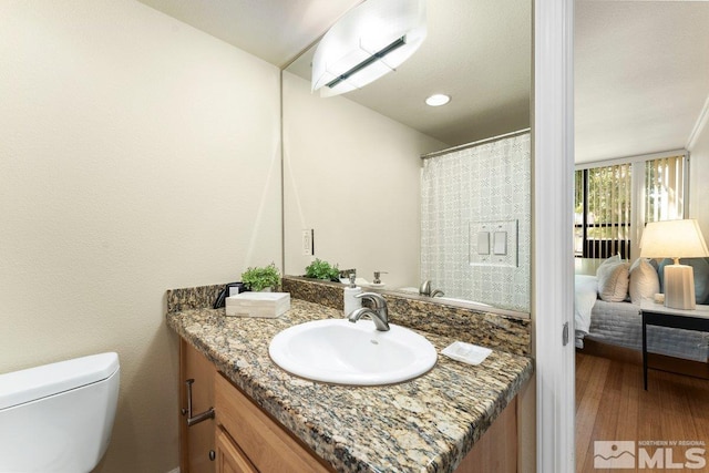 bathroom with vanity, hardwood / wood-style floors, and toilet