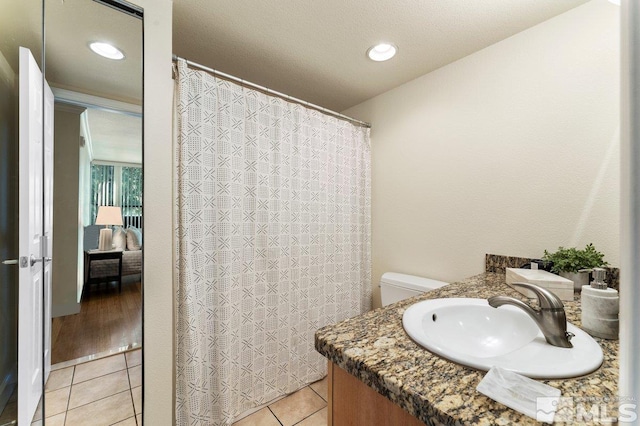 bathroom featuring vanity, toilet, and tile patterned flooring