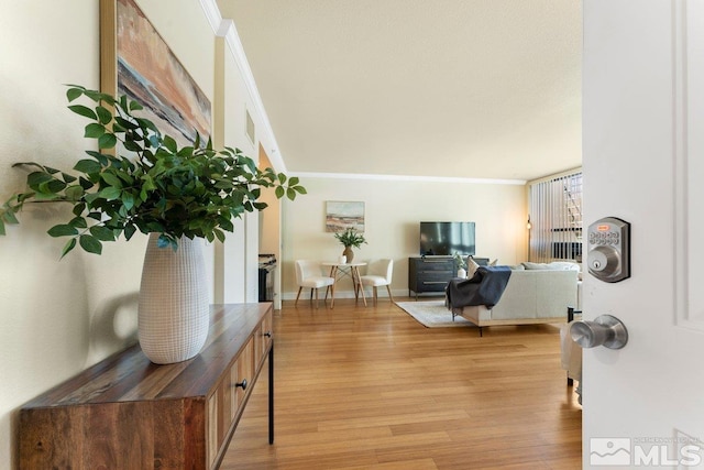 foyer with ornamental molding and light hardwood / wood-style flooring