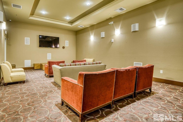 cinema room featuring carpet floors and a tray ceiling