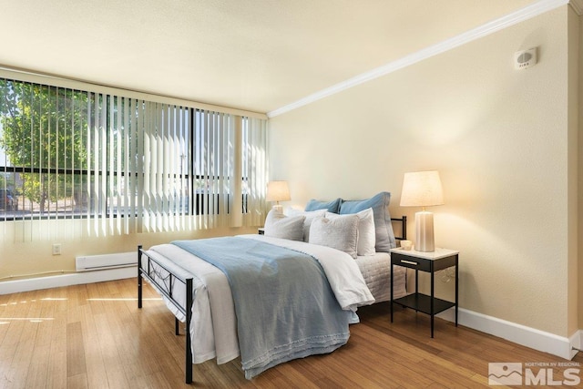 bedroom featuring ornamental molding and hardwood / wood-style floors