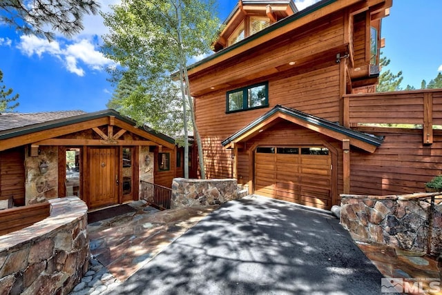 log-style house featuring a garage