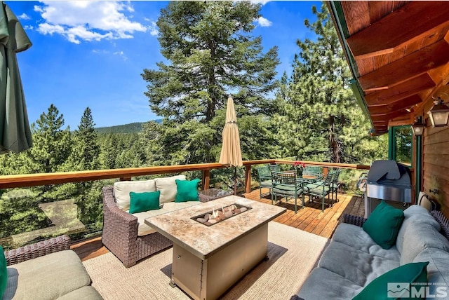 wooden deck with an outdoor living space with a fire pit and grilling area