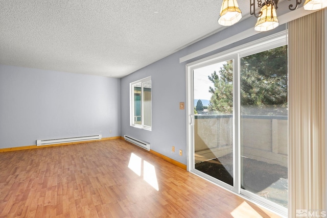 spare room featuring a textured ceiling, a baseboard heating unit, and wood-type flooring