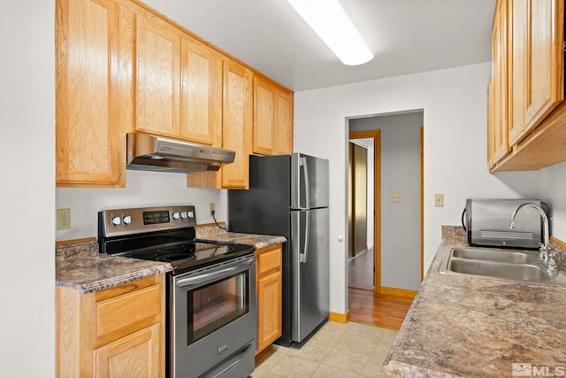 kitchen featuring light brown cabinets, exhaust hood, appliances with stainless steel finishes, light wood-type flooring, and sink