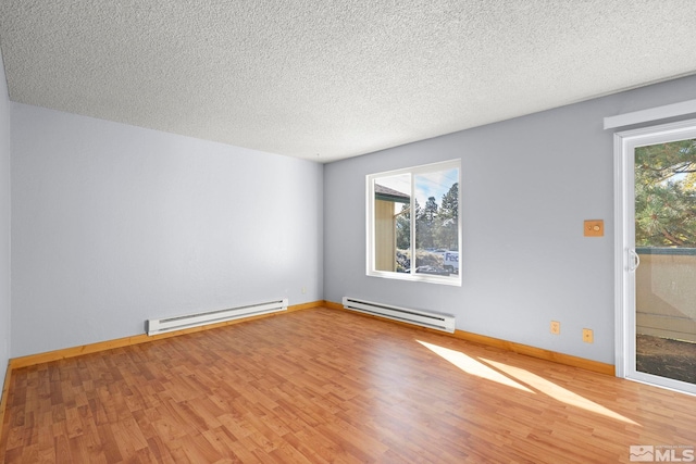 empty room with hardwood / wood-style floors, a baseboard heating unit, and a textured ceiling